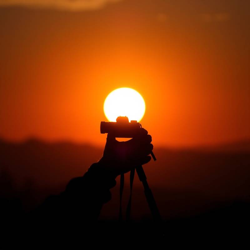 A photographer taking a picture at sunset